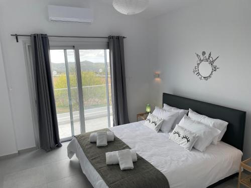 卡西卡斯Villa Phos的卧室配有一张大白色床和窗户