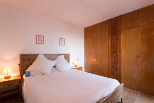 萨拉比塔Chalet Sa Rapita的卧室配有一张白色大床和木制橱柜。