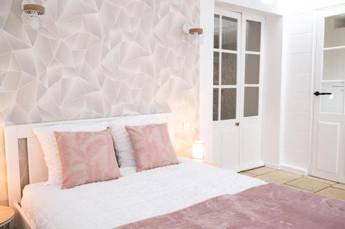 尼奥尔Appartement rénové - wifi - jardin - centre de Niort的卧室配有白色床和粉红色枕头