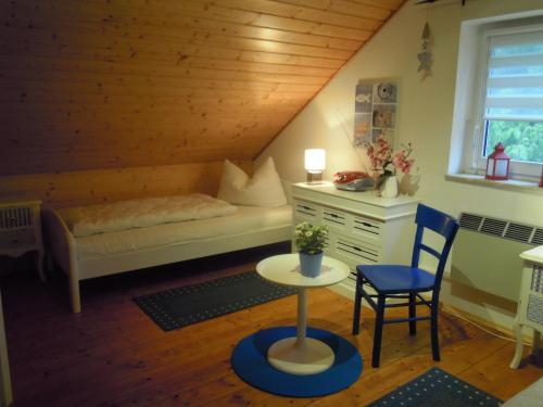 SilzFerienhaus am Fleesensee的卧室配有1张床、1张桌子和1把椅子