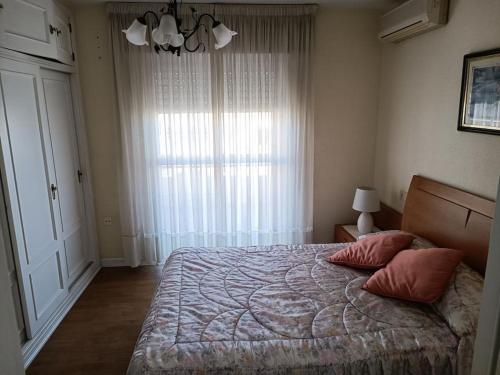 阿瓜杜尔塞Gran vivienda unifamiliar céntrica y cercana al mar的一间卧室配有带两个枕头的床和窗户