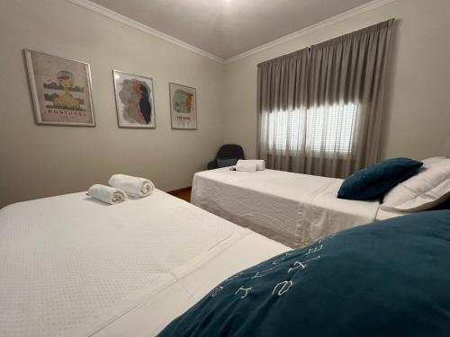 丰沙尔Dona I House - In Funchal with free parking的客房设有两张床和窗户。