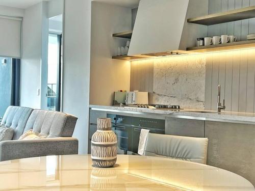 悉尼City view designed apartment in Bondi Junction的一间带桌子的客厅和一间厨房