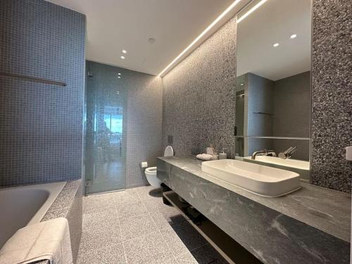 悉尼City view designed apartment in Bondi Junction的一间带水槽、浴缸和卫生间的浴室