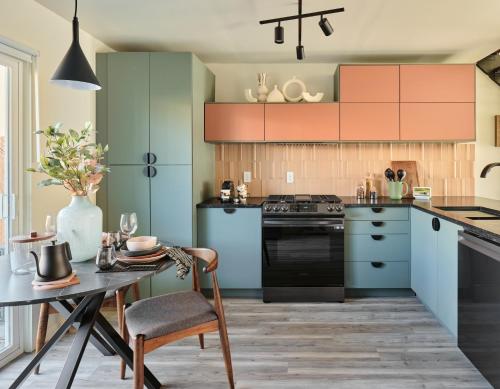 奥斯汀Midcentury Couples Designer Loft - Casa Tuya的厨房配有蓝色和绿色的橱柜和桌子