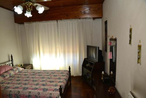 卢汉Departamento en Jauregui (partido de Luján)的一间卧室配有一张床和一台电视