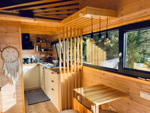 希迈The Grey Tiny的厨房设有木墙、桌子和窗户。