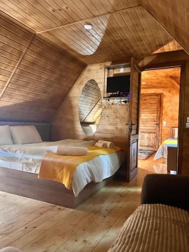库塔伊西Sunshine House的卧室配有一张床铺,位于带木墙的房间内