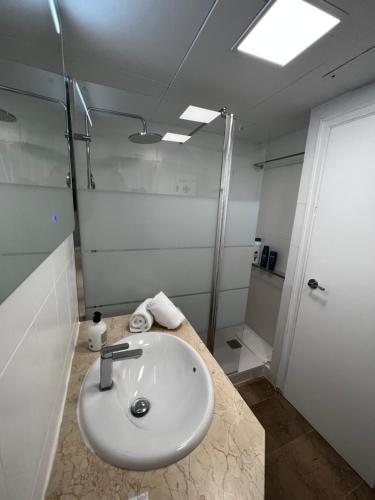 萨洛Apartamento a 3 minutos de la playa的浴室配有白色水槽和淋浴。