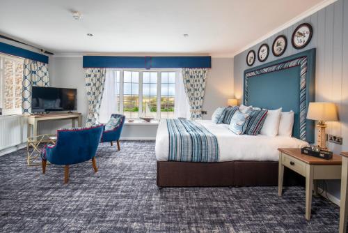 布莱克尼The Manor Coastal Hotel & Inn, Blakeney, Norfolk的酒店客房设有一张大床和一台电视。