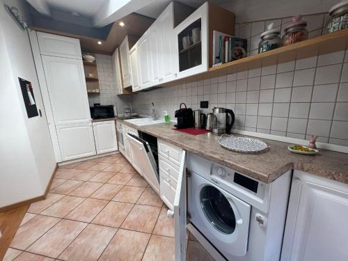 特伦托Ai Cappuccini, Trento a 360 gradi的厨房配有白色橱柜、洗衣机和烘干机