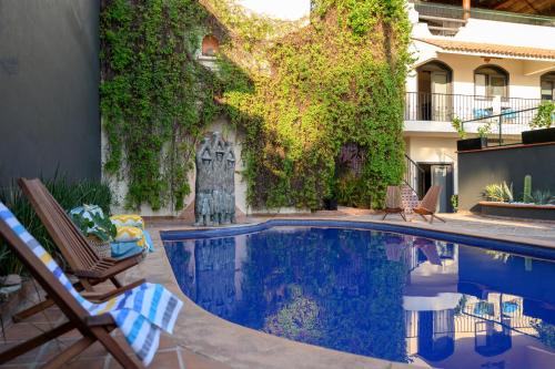 布塞里亚斯Villa Cobojo的一座带椅子的庭院和一座建筑中的游泳池