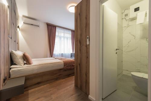 萨拉热窝Casa ARTEE Free Parking的一间带一张床、淋浴和卫生间的浴室