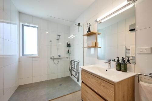 凯库拉Shearwater Apartments的白色的浴室设有水槽和淋浴。