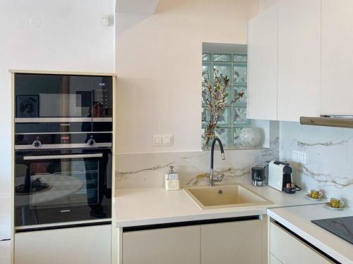 塞萨洛尼基East Coast Senses的白色的厨房配有水槽和微波炉