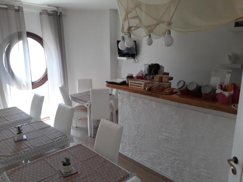 玛格丽塔萨沃亚Sweet Suite Margherita B&B的厨房配有白色的椅子、桌子和窗户