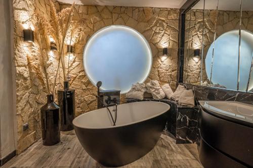 马拉喀什Palais Mirage d'Atlas - Restaurant & Spa & Day Pass的一间带大浴缸和大镜子的浴室