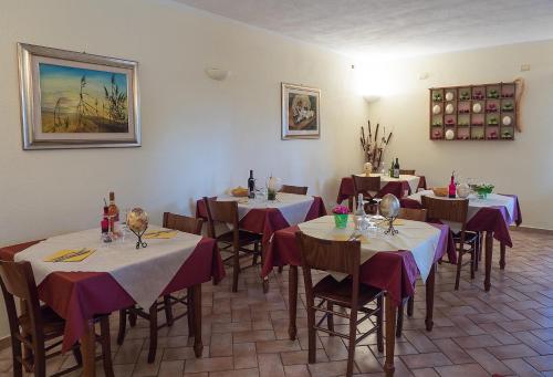佩夏罗马纳B&B Corte degli Struzzi的用餐室配有带紫色和白色桌布的桌子