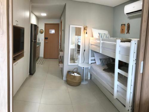 塔曼达雷Flat aconchegante no Eco Resort Praia dos Carneiros - Cama Queen的客房设有两张双层床和电视。