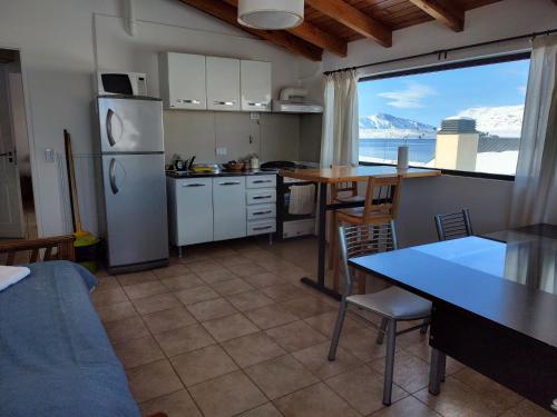 卡薇亚惠Cerro Pirámide Alojamiento的厨房配有冰箱和带餐桌的桌子