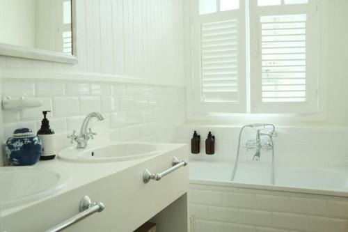 皮特尔角城Maison Victoire, Pointe-à-Pitre的白色的浴室设有水槽和浴缸。