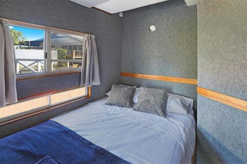 Pelican WatersCaloundra Houseboats的一间卧室设有一张大床和窗户