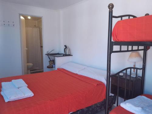 GualeguaychúMatices的一间卧室设有两张双层床和红色毯子