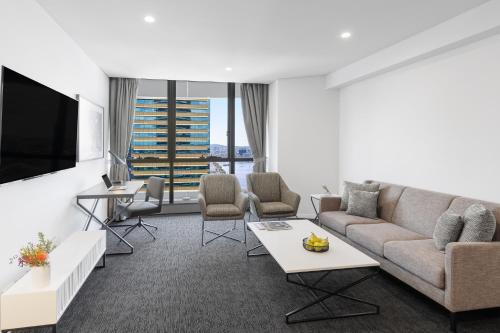 布里斯班Meriton Suites Herschel Street, Brisbane的带沙发和电视的客厅
