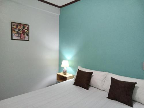 蒙特哥贝The Couples Inn的卧室配有白色床和蓝色墙壁