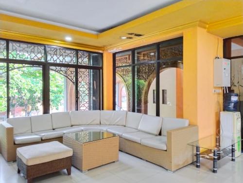 井里汶ISLAMIC GUEST HOUSE AT TAQWA的客厅配有白色沙发和一些窗户。