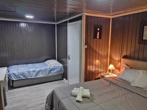 卡内拉Chalé D´Roos III的一间卧室配有一张床,上面有两条毛巾
