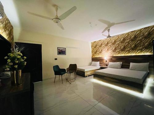 卡拉奇TULIP HOTELS AND APPARTMENTS的一间卧室配有一张床、一张沙发和椅子