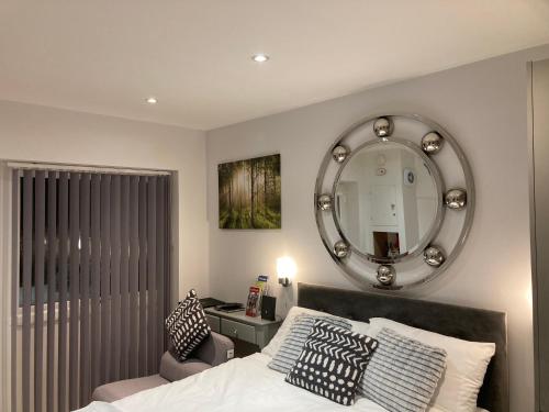 彭里斯Beautiful 1-Bed studio in Penrith的一间卧室配有一张带镜子和椅子的床