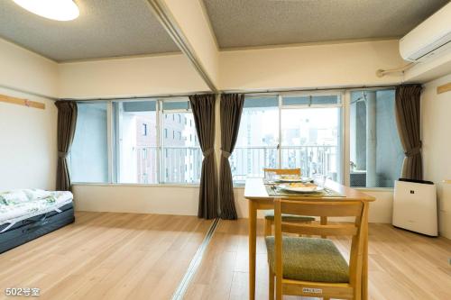 鹿儿岛Nanei Building - Vacation STAY 03606v的客房设有桌子、床和窗户。