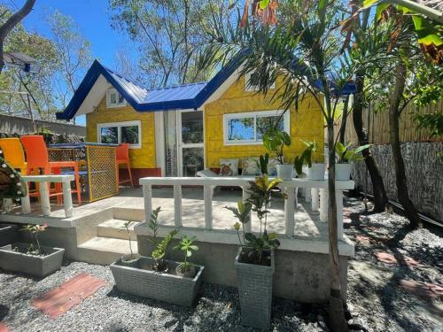 LingayenBeachfront Glamping with Mini Pool Exclusive Property的一座小黄房子,在院子里种有植物