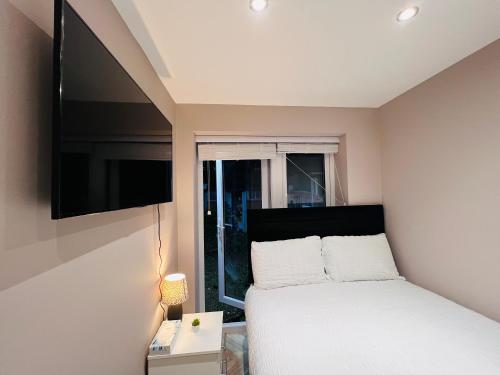 伦敦Cozzy的一间卧室配有一张床和一台平面电视