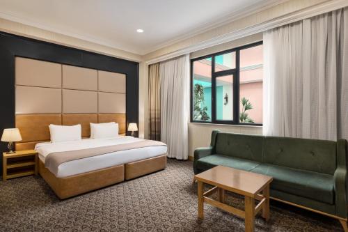 巴库Wyndham Baku的酒店客房,配有床和沙发