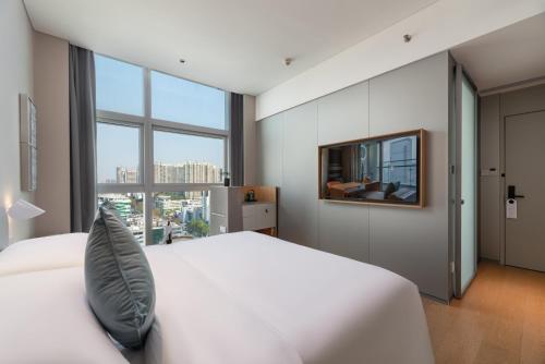 深圳深圳宝安前海Pagoda君亭设计酒店的卧室设有白色的床和大窗户