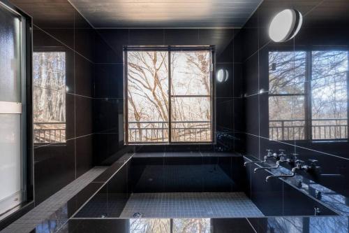 山中湖村tj resort YAMANAKAKO Luxury large villa with Mt. Fuji, Sauna BBQ Max 25的带浴缸和窗户的黑色浴室