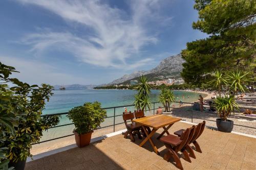 马卡尔斯卡Beach rooms Riviera - Žuta Kuća的俯瞰海滩的阳台配有桌椅
