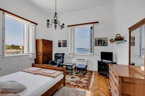 马卡尔斯卡Beach rooms Riviera - Žuta Kuća的卧室配有一张床、一张书桌和窗户。