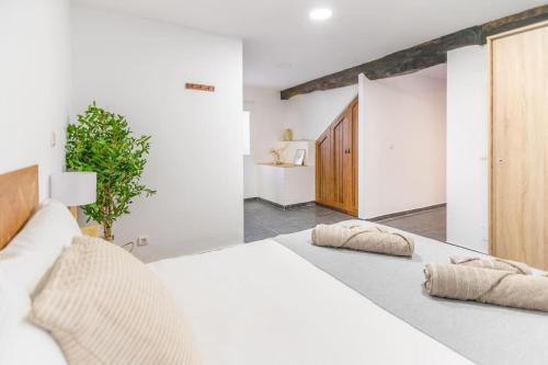 卡马乔Precioso piso estilo rústico a 10 min de Santander的卧室配有白色的床和两个枕头