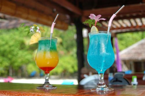 Pulau Mansuar拉贾安帕潜水旅馆的坐在桌子上喝两杯鸡尾酒