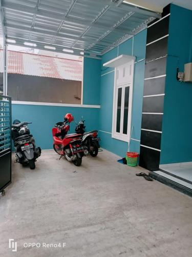 特尔纳特岛PENGINAPAN HKHAN的两辆摩托车停在一间蓝色墙壁的房间