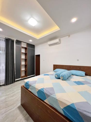 科贾扬Wisma Selma Garuda的一间卧室配有一张大床和蓝色枕头