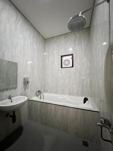 科贾扬Wisma Selma Garuda的带浴缸和盥洗盆的浴室