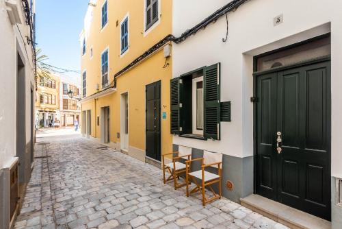休达德亚Holiday Home Casa Sant Pere by Mauter Villas的一座城市的街道,在一座建筑前有两把椅子