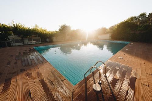阿赫尔Vall d'Àger Resort & Camping的木质甲板上的游泳池,阳光照耀