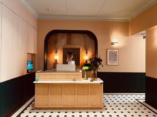 芒通伦敦酒店的大堂设有前台,镜子里有一个女人