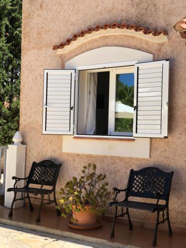 圣埃乌拉利亚Villa Casa Diego Ibiza的两把长椅,坐在窗前,有百叶窗